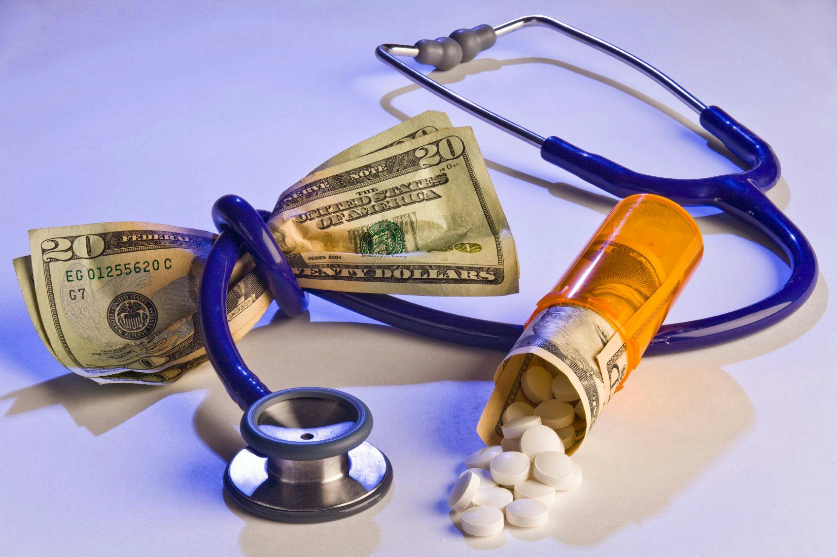 Cost of health care: money, pills, stethescope