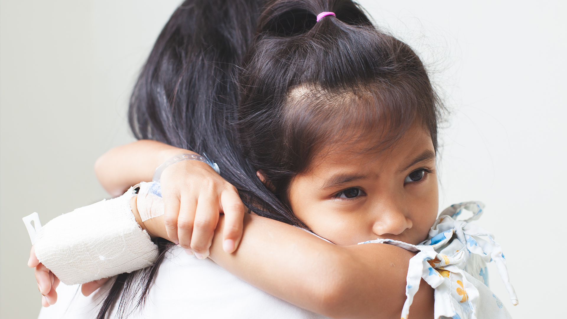 Sick asian child girl who have IV solution bandaged hugging her mother with love in the hospital © pingpao - stockadobe.com